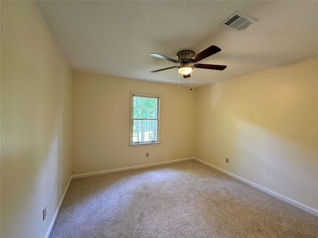 spare room featuring ceiling fan, baseboards, carpet flooring, and a textured ceiling