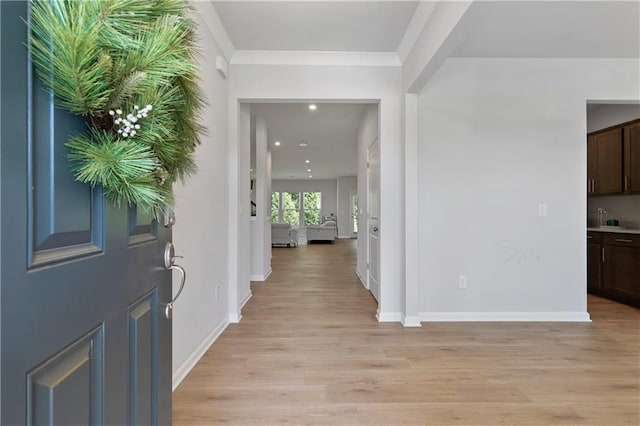 interior space featuring light wood-type flooring and crown molding