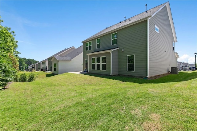 back of property with cooling unit and a yard