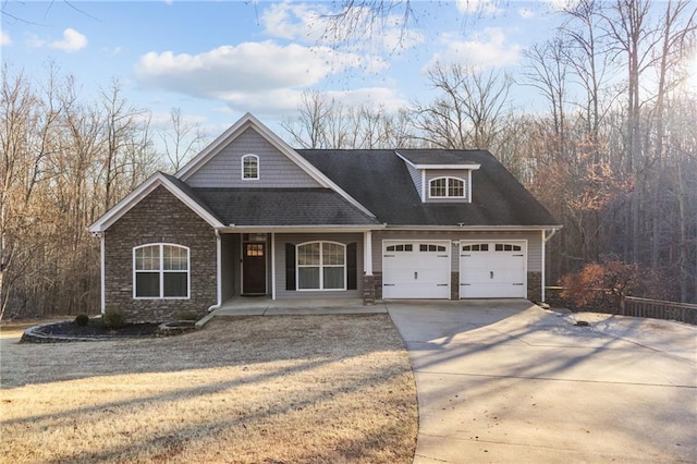 craftsman-style home with concrete driveway, a porch, and stone siding