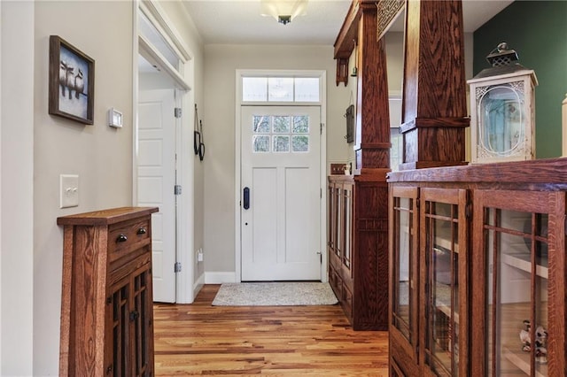 foyer entrance with baseboards and light wood-style floors