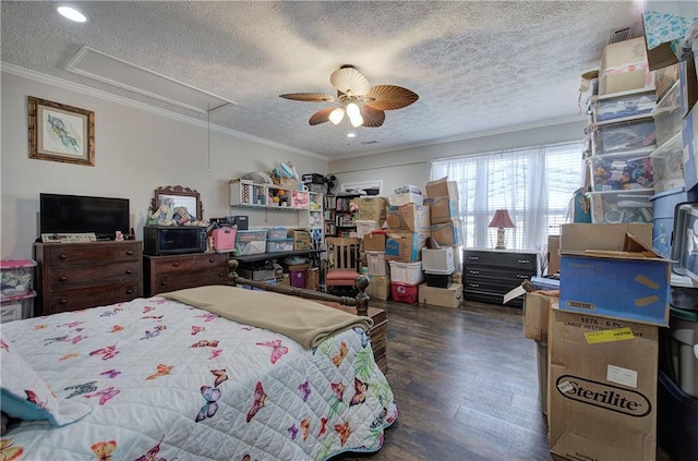 bedroom with attic access, ornamental molding, wood finished floors, a textured ceiling, and a ceiling fan