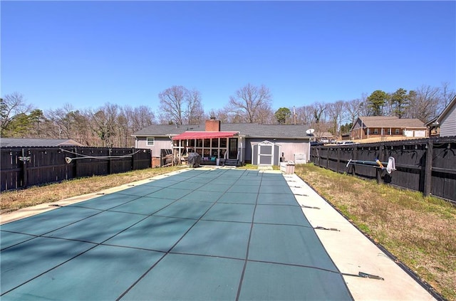 view of pool featuring a storage unit, an outbuilding, and a fenced backyard