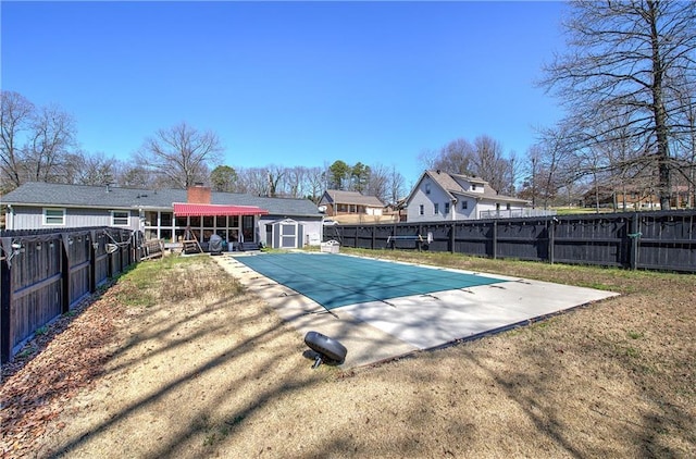 view of swimming pool featuring an outbuilding, a storage shed, a patio, and fence