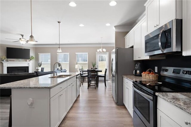 438 Crescent Woode Dr, Dallas, GA 30157 - kitchen featuring stainless steel appliances, a sink, light wood-type flooring, a fireplace, and ceiling fan with notable chandelier