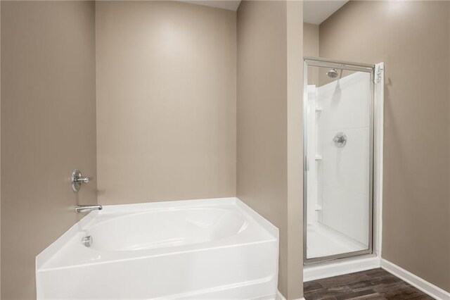 438 Crescent Woode Dr, Dallas, GA 30157 - full bath with baseboards, a garden tub, wood finished floors, and a stall shower