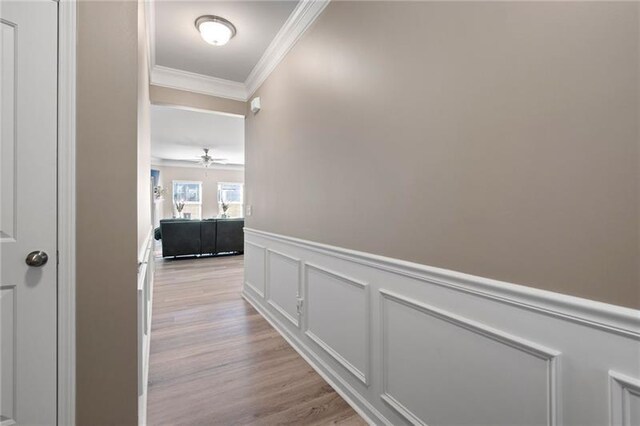 438 Crescent Woode Dr, Dallas, GA 30157 - hallway with light wood-type flooring, wainscoting, ornamental molding, and a decorative wall