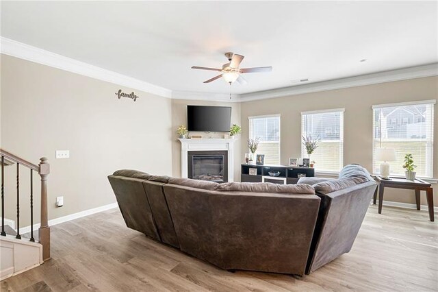 438 Crescent Woode Dr, Dallas, GA 30157 - living room featuring stairs, a glass covered fireplace, ceiling fan, light wood-style flooring, and baseboards