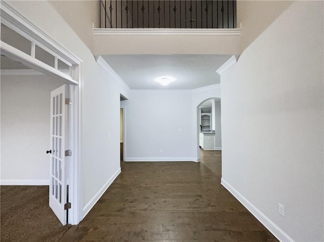 hall with dark wood-type flooring and ornamental molding