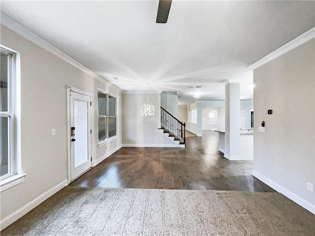 foyer featuring ornamental molding, dark hardwood / wood-style floors, a wealth of natural light, and an inviting chandelier