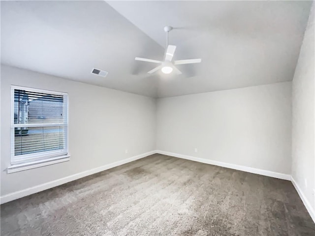 carpeted spare room featuring vaulted ceiling and ceiling fan