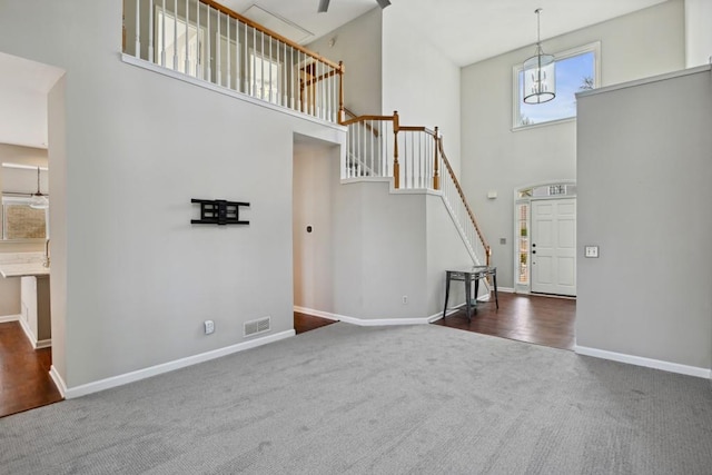 carpeted foyer entrance with a towering ceiling