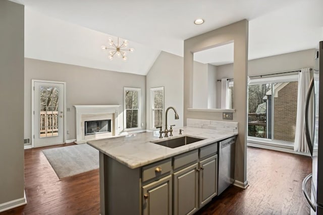 kitchen featuring sink, appliances with stainless steel finishes, gray cabinetry, dark hardwood / wood-style flooring, and light stone counters