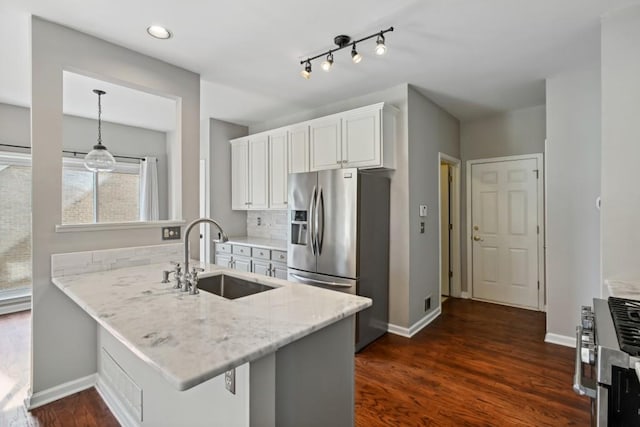 kitchen with a breakfast bar, kitchen peninsula, sink, stainless steel fridge with ice dispenser, and white cabinets