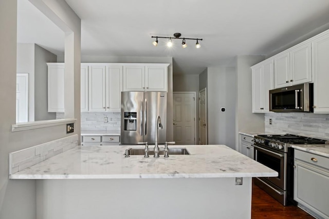 kitchen with white cabinets, light stone countertops, and stainless steel appliances