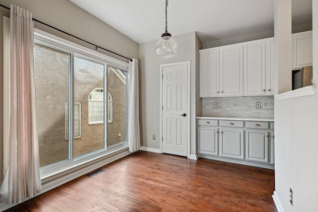 unfurnished dining area featuring dark hardwood / wood-style flooring