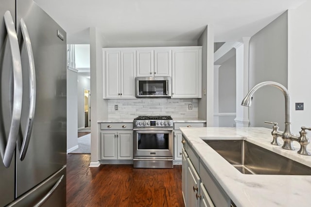 kitchen featuring light stone countertops, appliances with stainless steel finishes, tasteful backsplash, and sink