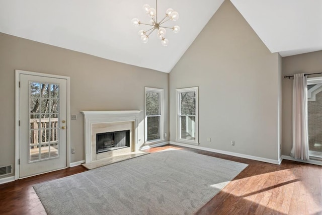 unfurnished living room featuring a chandelier, dark hardwood / wood-style floors, and high vaulted ceiling