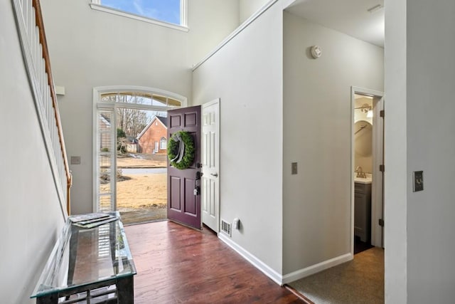 entryway with a towering ceiling, dark hardwood / wood-style floors, and sink