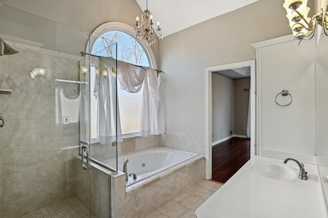 bathroom with an inviting chandelier, plus walk in shower, vaulted ceiling, a wealth of natural light, and sink