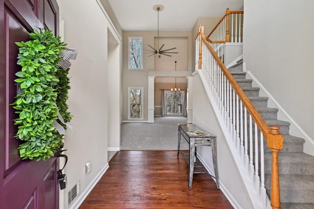 entrance foyer featuring dark wood-type flooring, plenty of natural light, and ceiling fan with notable chandelier