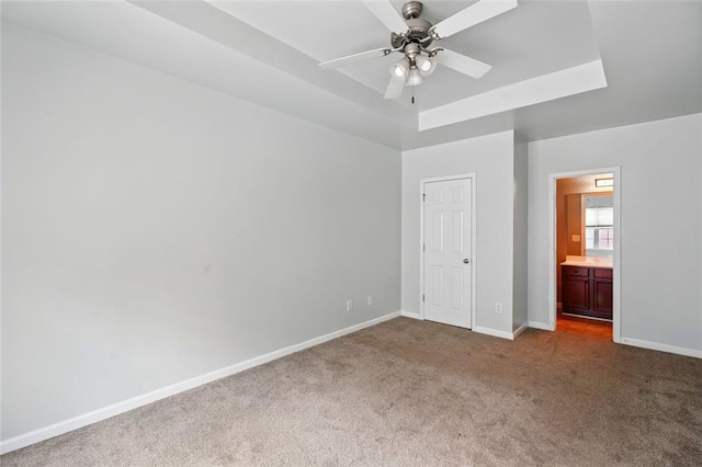 unfurnished bedroom featuring ensuite bath, carpet flooring, and baseboards