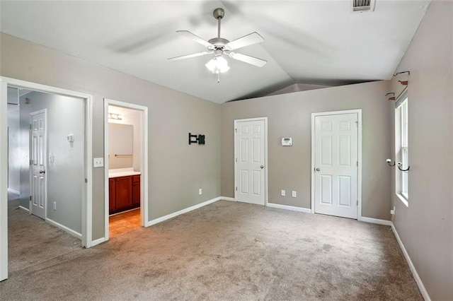 unfurnished bedroom with light colored carpet, lofted ceiling, baseboards, and visible vents
