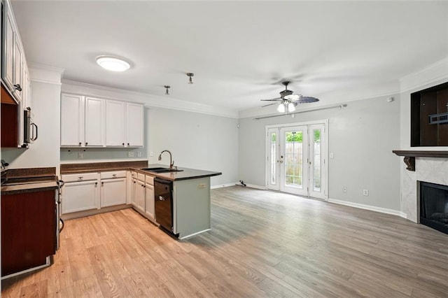 kitchen with a sink, a peninsula, ceiling fan, open floor plan, and dark countertops