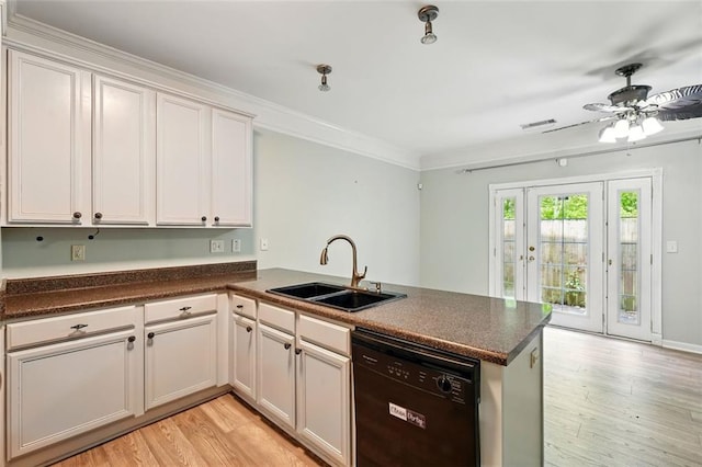 kitchen with dark countertops, a peninsula, a sink, and dishwasher