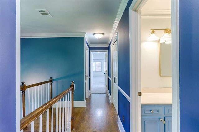 corridor with crown molding, dark wood finished floors, and baseboards