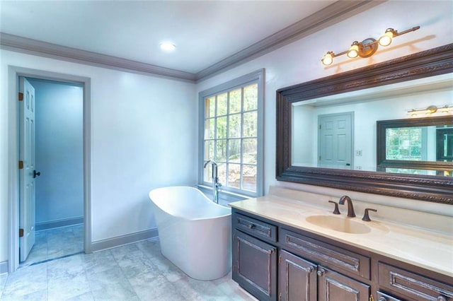bathroom with ornamental molding, a freestanding tub, vanity, and baseboards