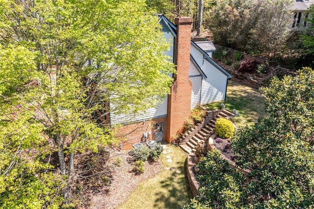 view of side of home featuring stairs and a chimney