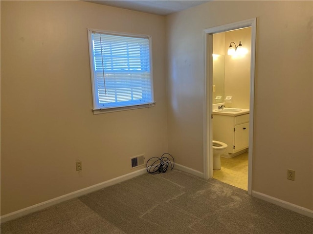 unfurnished bedroom with carpet, sink, and connected bathroom