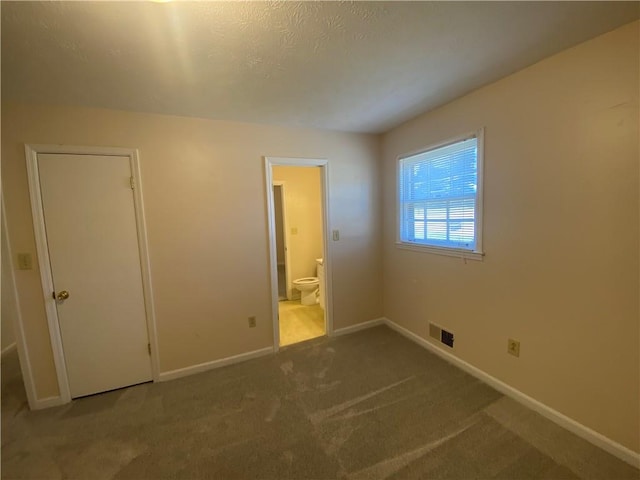 unfurnished bedroom featuring carpet flooring, connected bathroom, and a closet