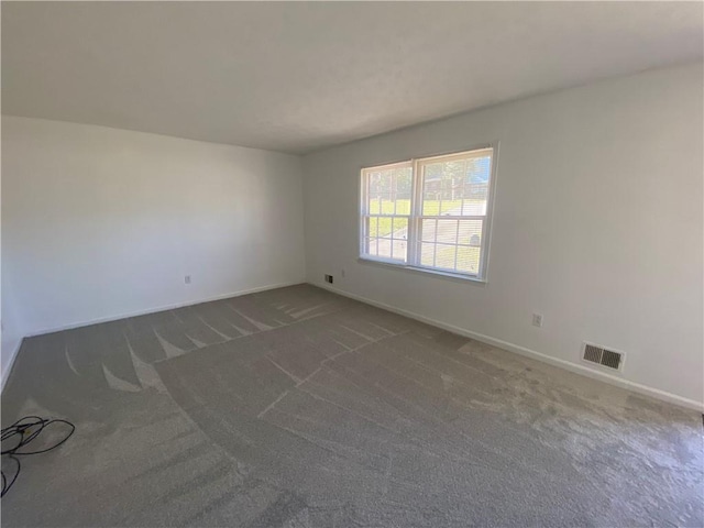 spare room with dark carpet