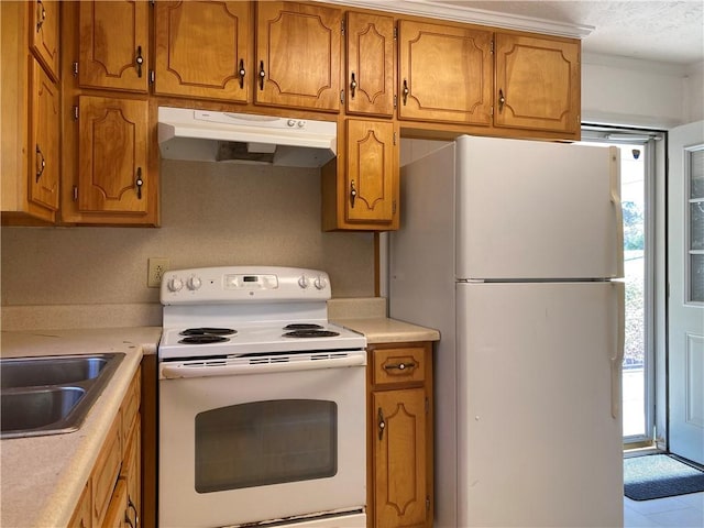 kitchen with sink, white appliances, and tile patterned flooring