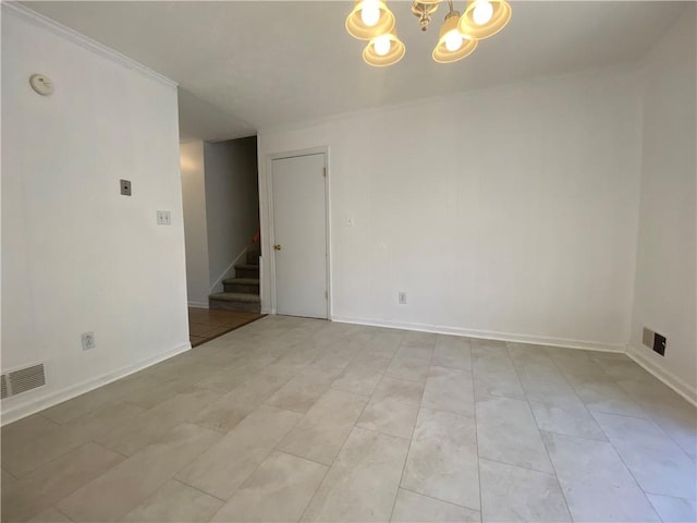 tiled empty room with ornamental molding and a chandelier