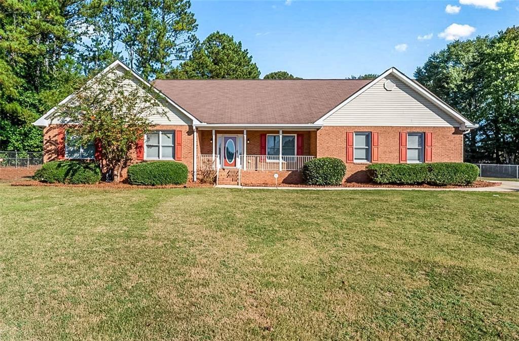 497 Freedom Dr, Mcdonough, GA 30252 - single story home with a front lawn, fence, covered porch, and brick siding