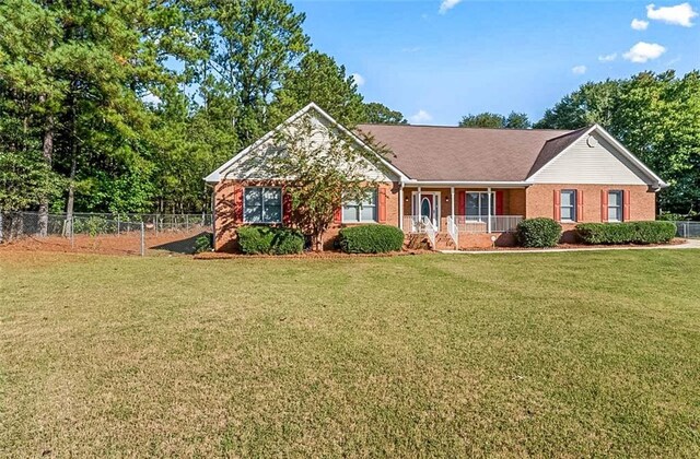 ranch-style home with a front yard and a porch