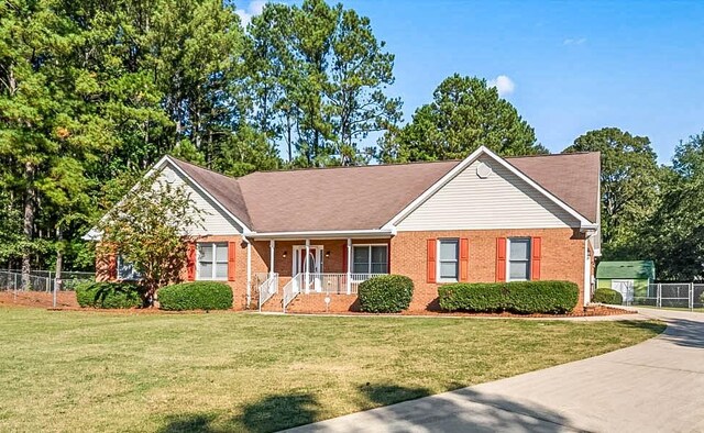 single story home featuring a front lawn and covered porch