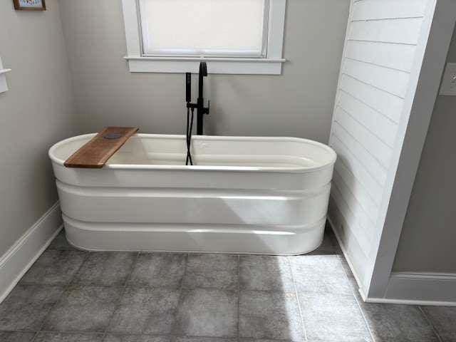 23 Poplar St, Porterdale, GA 30014 - full bathroom with a freestanding tub and baseboards