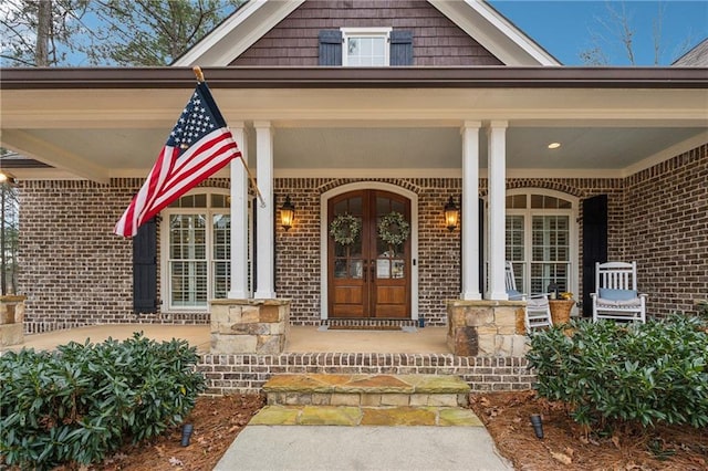 doorway to property featuring a porch and french doors