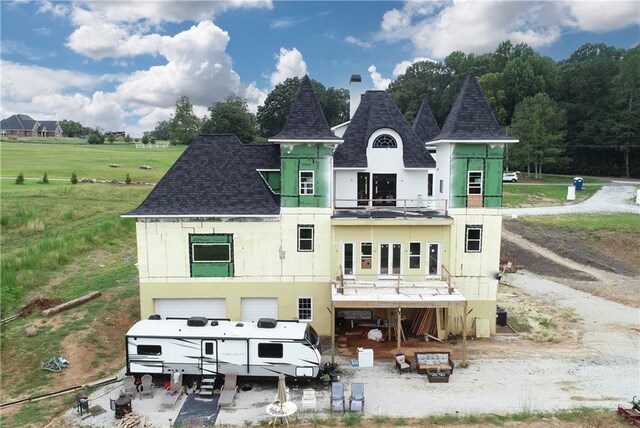 rear view of house featuring a balcony and a lawn