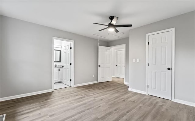 unfurnished bedroom featuring attic access, visible vents, baseboards, and wood finished floors