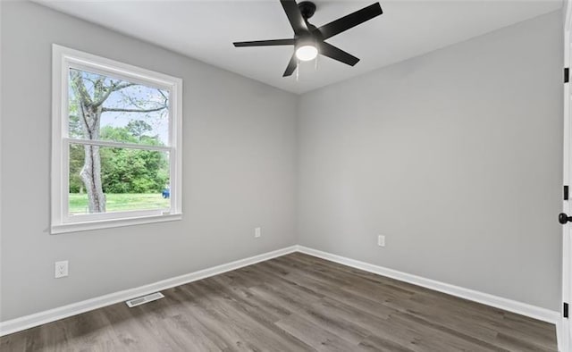 empty room featuring ceiling fan, wood finished floors, visible vents, and baseboards