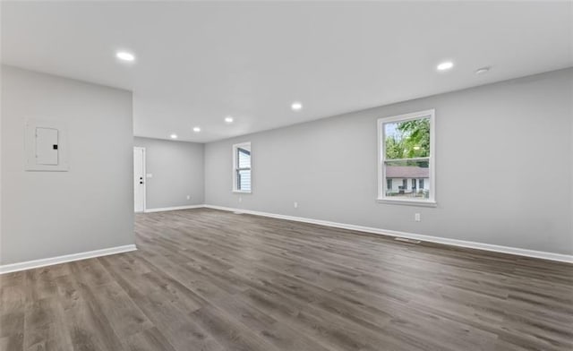 spare room with plenty of natural light, dark wood finished floors, and baseboards