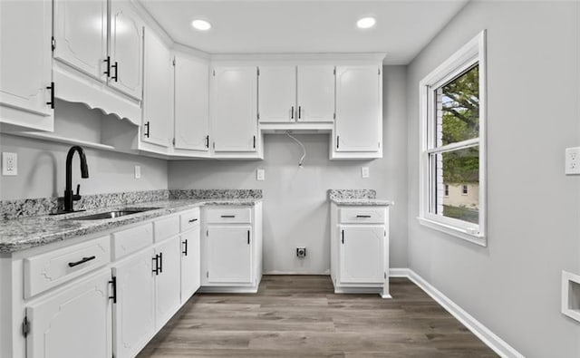 kitchen featuring dark wood-style flooring, recessed lighting, white cabinetry, a sink, and baseboards