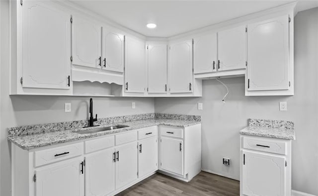 kitchen featuring open shelves, wood finished floors, a sink, and white cabinetry