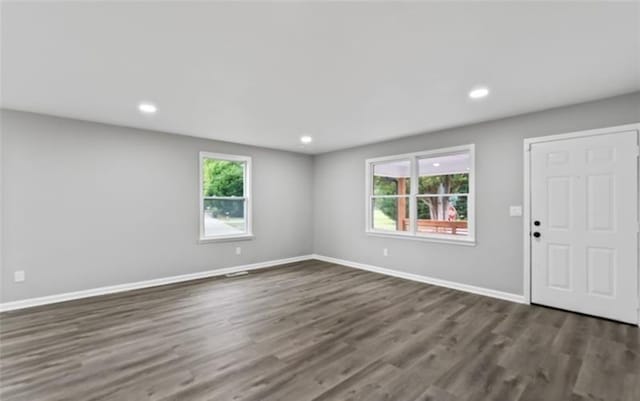 interior space featuring a wealth of natural light, dark wood finished floors, baseboards, and recessed lighting