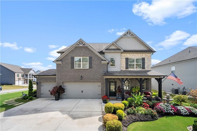 craftsman house featuring a porch, a garage, and central AC unit